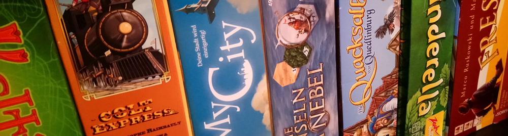 Aufgereihte Brettspiele im Regal